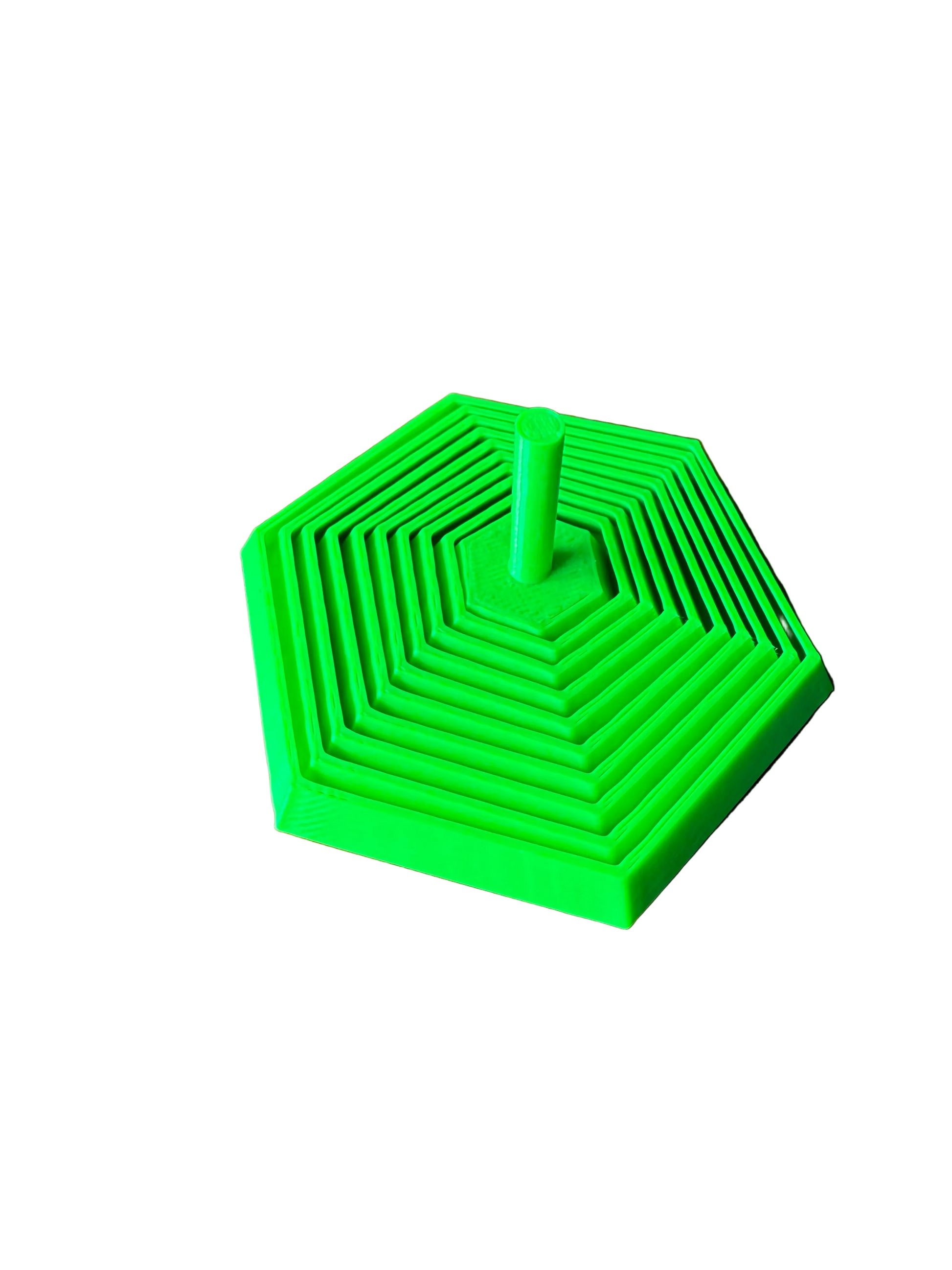 A bright green 3D-printed hexagonal nesting toy or puzzle with concentric square patterns and a central post, resting on a wooden tabletop.